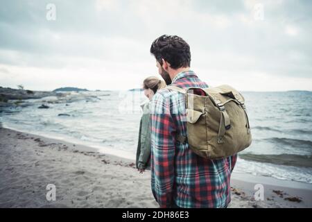 Vue latérale sur les couples merveilleux qui marchent sur la plage Banque D'Images
