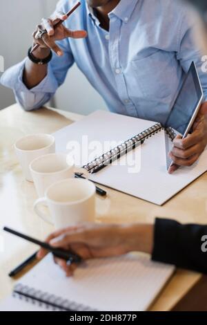 Image rognée des hommes d'affaires discutant à table Banque D'Images
