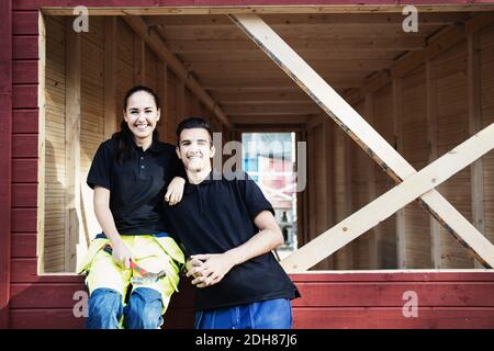 Portrait des étudiants en charpenterie heureux à l'extérieur de la cabine en bois Banque D'Images