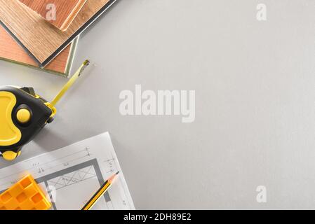 Détail des matériaux et des outils sur la table de travail d'un installateur de parquet avec des plans. Vue de dessus. Banque D'Images