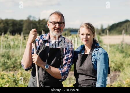 Portrait de fermiers heureux debout dans la ferme biologique Banque D'Images