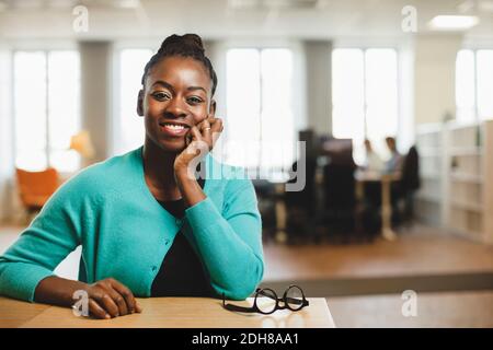 Portrait d'une femme souriante avec la main sur le menton tableau Banque D'Images