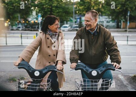 Un bon couple senior prend des vélos de location sur le parking Banque D'Images