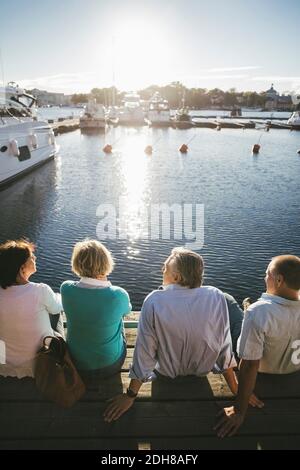 Vue arrière de deux couples âgés se détendant sur la jetée Banque D'Images