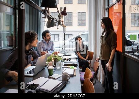 Femme d'affaires donnant la présentation à des collègues dans le bureau créatif Banque D'Images