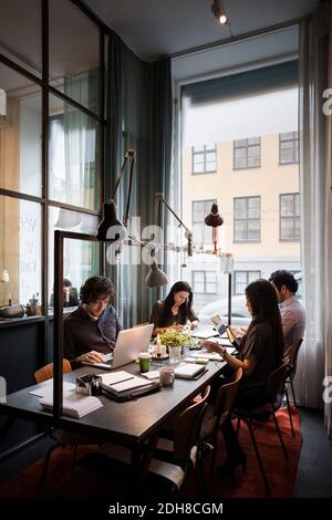 Équipe d'affaires créative assise à table, travaillant dans un bureau moderne Banque D'Images