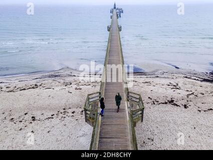 Boltenhagen, Allemagne. 10 décembre 2020. Deux femmes marchent dans le brouillard sur la jetée. (Vue aérienne avec un drone) en raison du verrouillage partiel de la couronne, les hôtels, les restaurants et les installations touristiques sur la côte de la mer Baltique dans le Mecklembourg-Poméranie occidentale sont fermés. Credit: Jens Büttner/dpa-Zentralbild/dpa/Alay Live News Banque D'Images