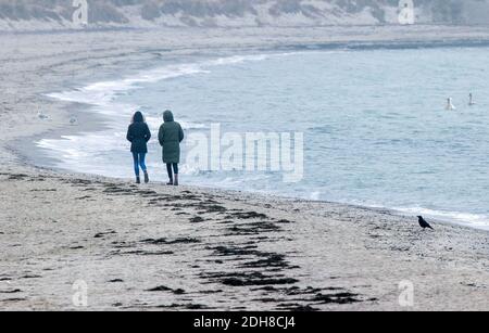Boltenhagen, Allemagne. 10 décembre 2020. Deux femmes marchent dans le brouillard sur la plage de la mer Baltique. En raison du verrouillage partiel de la couronne, les hôtels, les restaurants et les installations touristiques sur la côte de la mer Baltique dans le Mecklembourg-Poméranie-Occidentale sont fermés. Credit: Jens Büttner/dpa-Zentralbild/dpa/Alay Live News Banque D'Images