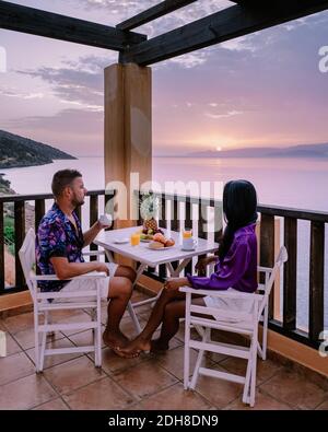 Table et chaises avec petit déjeuner au lever du soleil au méditarien mer en Grèce Banque D'Images