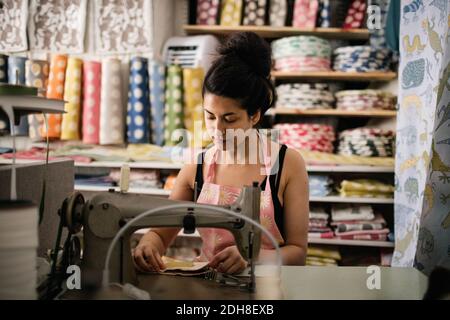 Femme à coudre du textile en travaillant dans une boutique de tissus Banque D'Images