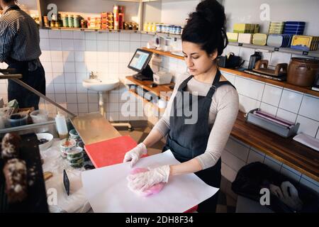 Un jeune propriétaire sérieux empaquetage du poisson en magasin Banque D'Images