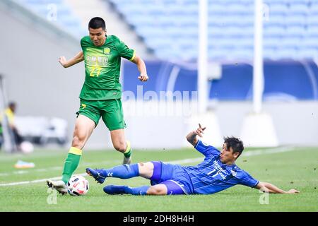 Le joueur de football professionnel sud-coréen Lee Keun-ho d'Ulsan Hyundai, à droite, vole le ballon lors du quart de finale du match des champions L de l'AFC 20/21 Banque D'Images