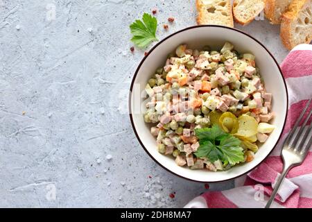 Salade russe « Olivier » de légumes bouillis et saucisse avec mayonnaise. Vue de dessus avec espace de copie. Banque D'Images