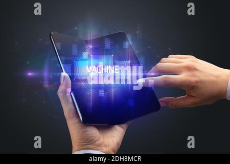 Businessman holding a smartphone pliable avec inscription de la machine, la nouvelle technologie concept Businessman holding a smartphone pliable avec inscription de la machine, la nouvelle technologie concept