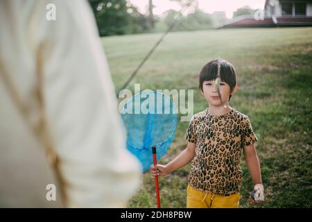 Portrait de fille avec filet de pêche debout dans l'arrière-cour Banque D'Images