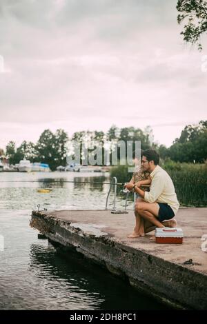 Vue latérale du père et de la fille pêche dans le lac pendant été Banque D'Images