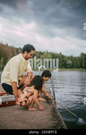 Père avec des filles pêchant pendant l'été Banque D'Images