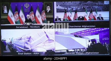 Téhéran, Iran. 10 décembre 2020. Une photo mise à disposition par le site officiel du bureau présidentiel iranien d'un écran montrant la cérémonie d'inauguration des opérations ferroviaires de Herat-Khaf reliant l'Iran et l'Afghanistan, à Téhéran, en Iran, le 10 décembre 2020. Le chemin de fer Herat-Khaf, officiellement ouvert le 10 décembre, est une voie de 130 km de long reliant la ville iranienne de Khaf à la province occidentale de Herat en Afghanistan, fournissant une liaison de transport cruciale pour l'Afghanistan sans littoral. Credit: Présidence iranienne/ZUMA Wire/Alamy Live News Banque D'Images