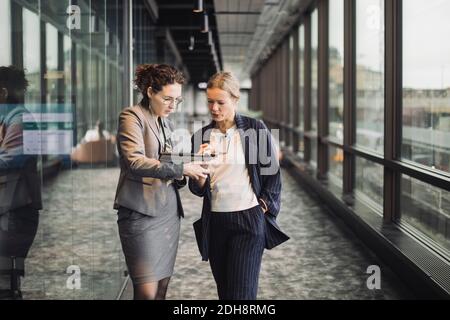 Les professionnels des affaires discutent dans le couloir sur le lieu de travail Banque D'Images