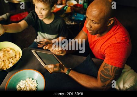 Vue en grand angle de l'homme avec une tablette numérique par garçon pendant un événement sportif Banque D'Images