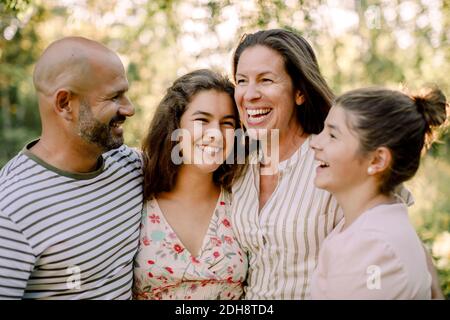 Famille souriante passant du temps ensemble tout en appréciant dans la cour pendant été Banque D'Images