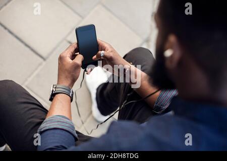 Vue en grand angle de l'homme surfant sur le net sur mobile téléphone Banque D'Images