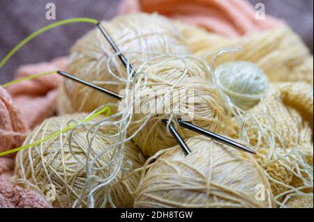 Aiguilles à tricoter, pelins de fil et de tissu tricoté, travaux d'aiguille à domicile. Gros plan, mise au point sélective Banque D'Images