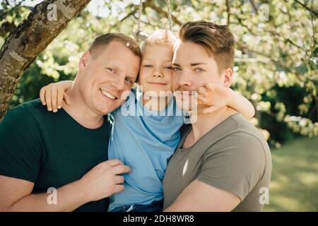Portrait de pères homosexuels avec fils debout dans la cour Banque D'Images
