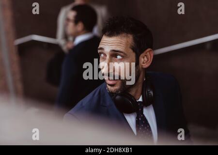 Homme d'affaires avec un casque qui regarde loin en ville Banque D'Images