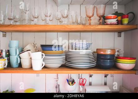 Vaisselle et verres à boire sur les étagères de la cuisine à la maison Banque D'Images