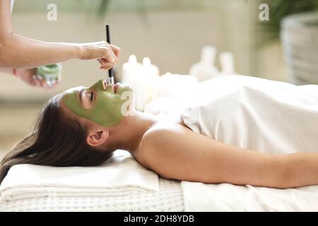 Belle femme détendue ayant le masque de visage d'argile Banque D'Images