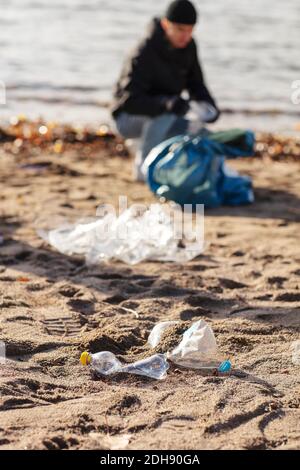 Jeune environnementaliste collectant les déchets plastiques par lac Banque D'Images