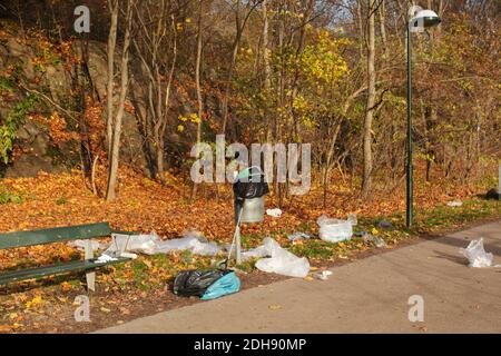 Vue en grand angle des déchets de plastique éparpillé sur un banc parc en automne Banque D'Images