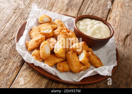 Le célèbre aliment de rue hollandais Kibbeling se compose de morceaux de poisson de morue qui sont trempés dans la pâte, frits et servis avec une sauce à tremper près Banque D'Images