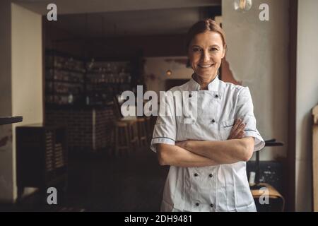 Portrait d'un chef souriant aux bras croisés dans le restaurant Banque D'Images