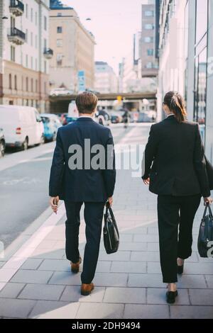 Vue arrière des gens d'affaires qui marchent sur le trottoir Banque D'Images