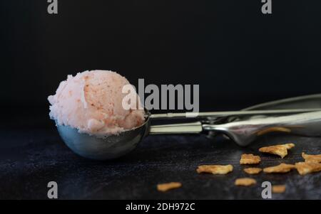 Ice cream scoop on dark background. Low key light strawberry ice cream. Banque D'Images