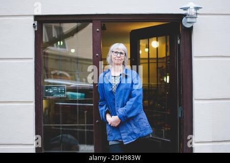 Portrait d'une femme confiante debout à la porte de bijoux stocker Banque D'Images