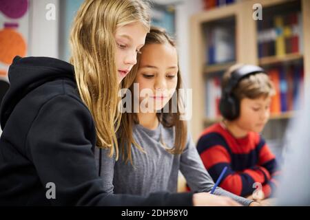Girls studying together in classroom Banque D'Images