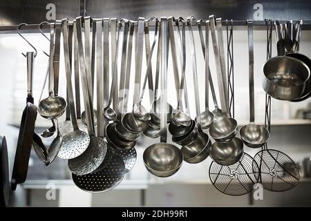 Ustensiles sur un support en métal dans une cuisine commerciale Banque D'Images