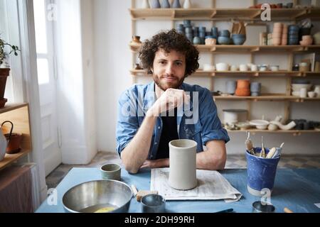 Portrait d'un homme adulte du milieu assis en poterie Banque D'Images