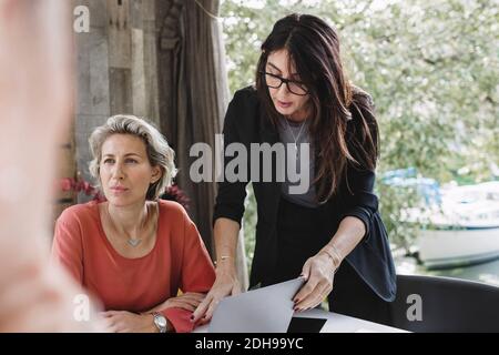 Femme d'affaires debout par un collègue attentif dans un camion de bureau portable Banque D'Images