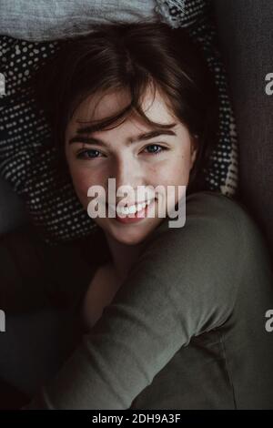 Portrait of smiling woman on sofa Banque D'Images