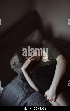 Vue en grand angle de la jeune femme allongé sur le lit à accueil Banque D'Images