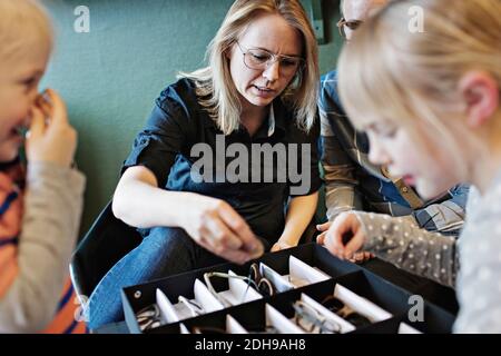 Famille organisant des lunettes dans une boîte à l'atelier Banque D'Images