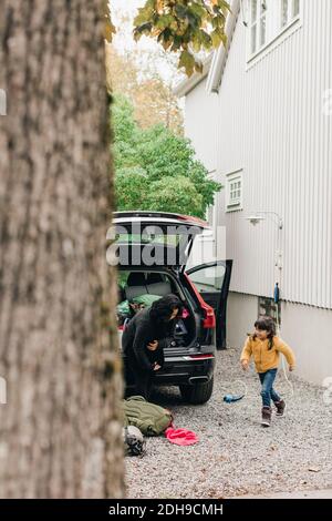 Famille chargeant des bagages dans le coffre de voiture électrique Banque D'Images