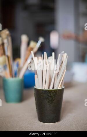 Outils en bois dans un récipient sur la table à l'atelier Banque D'Images