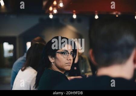 Femme d'affaires confiante assise avec des collègues dans la salle du conseil Banque D'Images