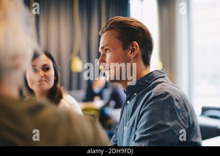 Vue latérale d'une femme d'affaires confiante assise avec des collègues féminins salle du conseil Banque D'Images