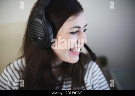Gros plan d'une jeune femme souriante portant un casque à la maison Banque D'Images